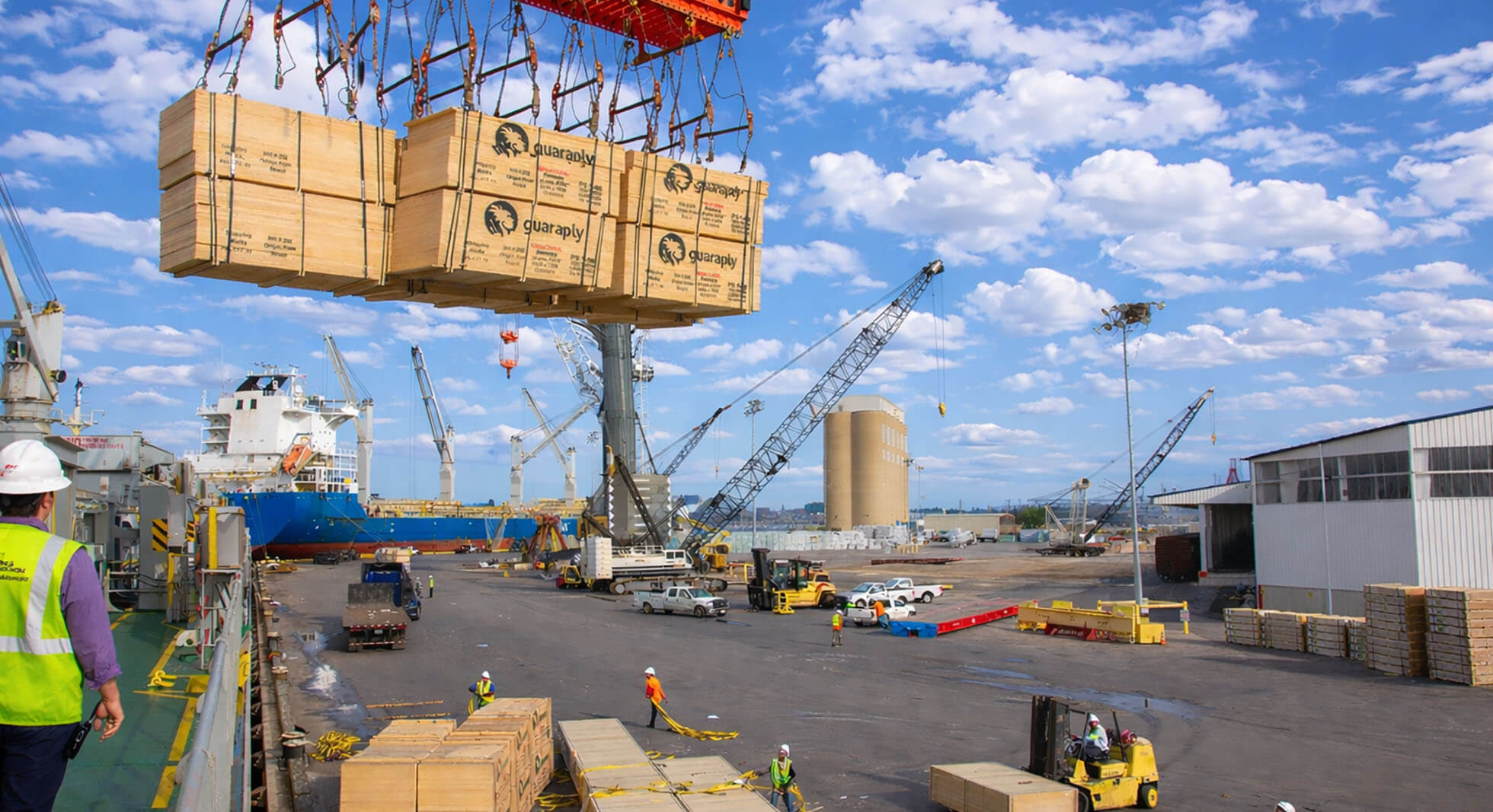 stevedores watching dimensional lumber being offloaded by ship's gear at rukert terminals